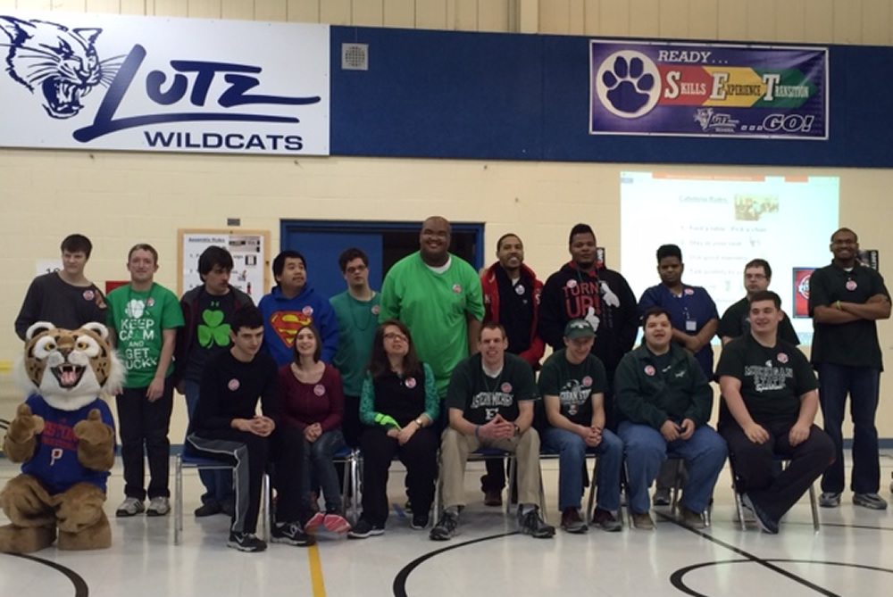 Student assembly in the gym with the school mascot, Paws.